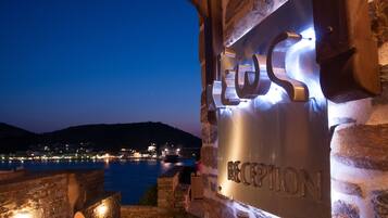Un edificio de piedra con un cartel que dice "RECEPTION" iluminado por luces.