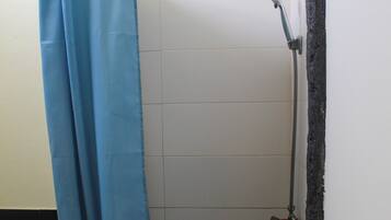 Un espace douche avec un rideau de douche bleu, des toilettes blanches et un porte-serviettes.