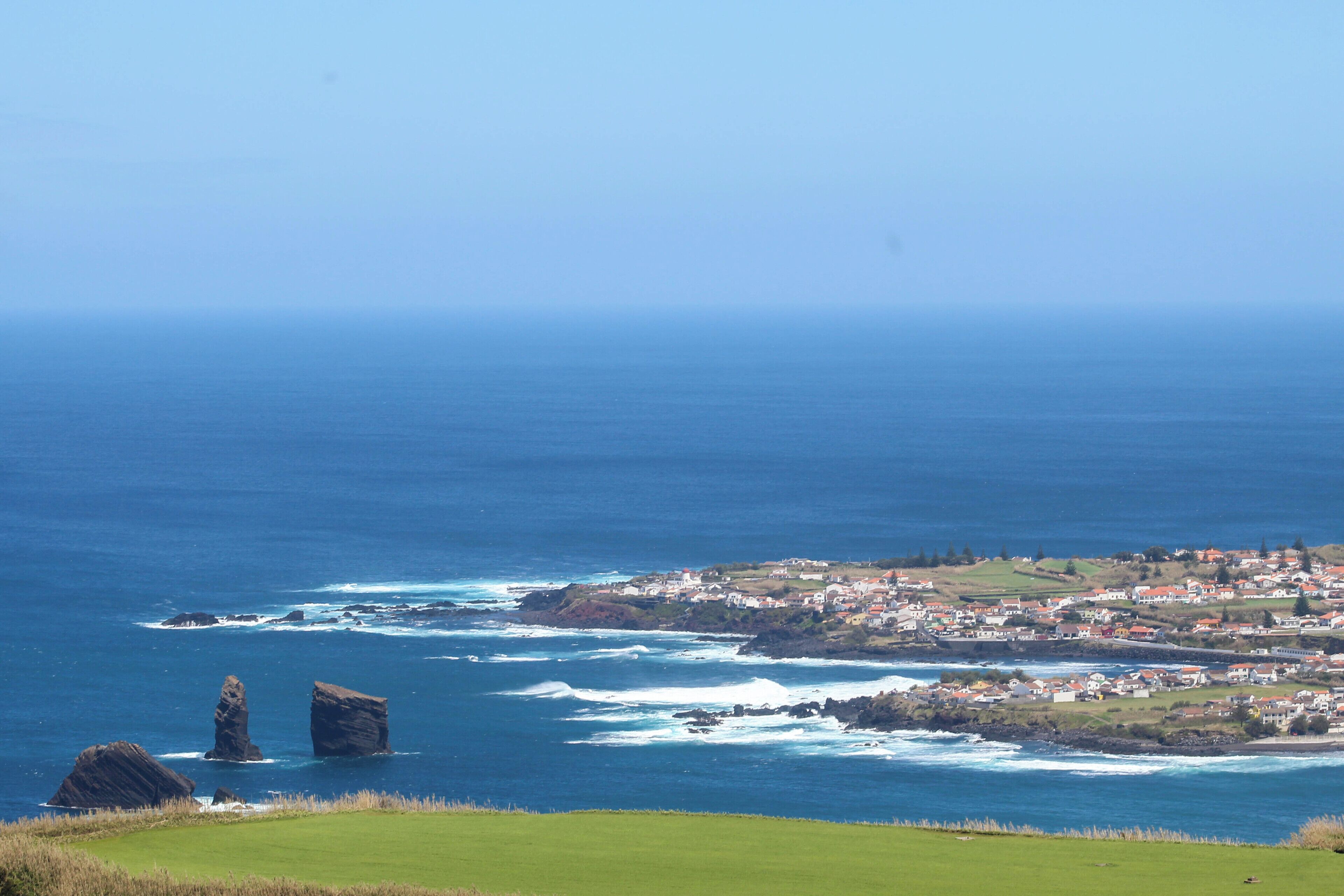 A coastal town with rocky outcrops and a view of the ocean.