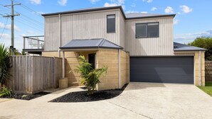 A two-story house with a garage, a small porch, and a fenced yard. - Beachside Escape in Cowes (Cowes)