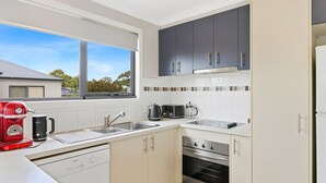 A modern kitchen with a dishwasher, oven, and a coffee machine. - Beachside Escape in Cowes (Cowes)