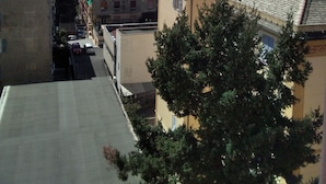 A coastal urban area with buildings, a narrow street, and a view of the sea.