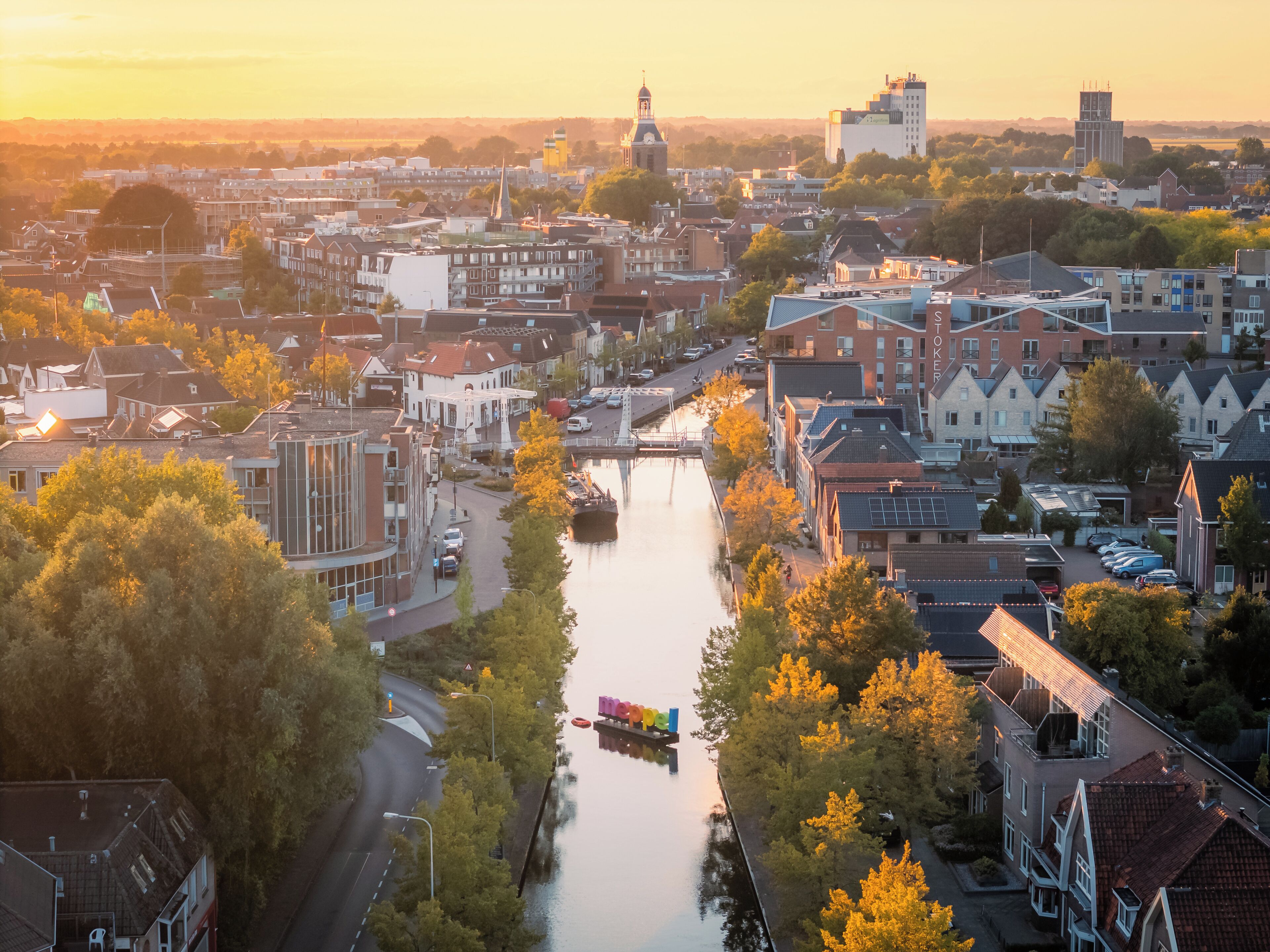 A river running through a city with buildings on both sides. There is a bridge crossing the river, and the buildings are of various architectural styles.