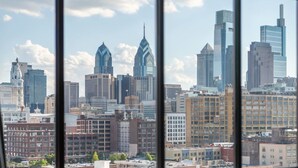 A city skyline with various buildings, including a prominent skyscraper with a pointed top. - Sosuite 2BR Penthouse w W D Gym On-site Bar (Philadelphia)