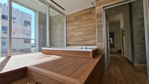 A modern interior with a wooden bench, large windows, and a view of the city. - Hotel Del Bono Central (San Juan)