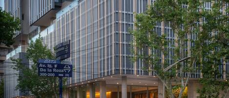Un hotel moderno con facciata in vetro, ingresso ben visibile e insegna con l'indirizzo.