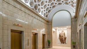 A lobby with marble walls, three elevators, and a statue. - Sosuite Micro Studio w Shared W D Gym Lounge (Philadelphia)