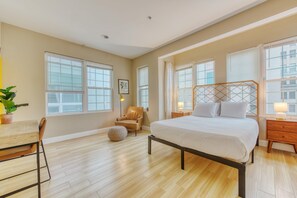 A bedroom with a bed, a chair, a desk, and a potted plant. - Cherry Suites 3BR Apt w W D Foosball Table (Philadelphia)