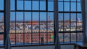 Ein Zimmer mit großen Fenstern und Blick auf die Stadt, einschließlich Gebäude und einer Brücke.