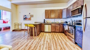 A modern kitchen with wooden cabinets, a stainless steel dishwasher, and a built-in oven. - Sosuite 2BR Apt w W/d, Gym, On-site Restaurant (Philadelphia)