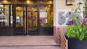 The entrance to Independence Suites with a bar sign and a large number '59' sign.