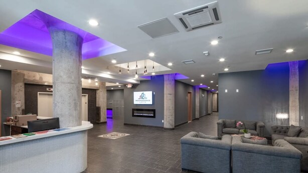 A modern lobby with a reception desk, seating area, and a large screen displaying 'INDEPENDENCE'.