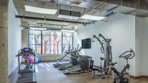 A gym with treadmills, elliptical machines, and a stationary bike.