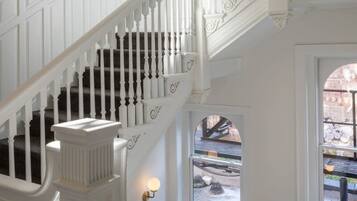 A grand staircase with white balustrades and dark steps, leading to an upper floor.