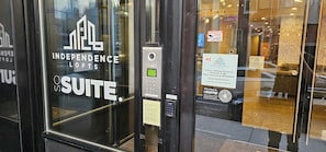 A hotel entrance with a sign for 'Independence Suites' and a keypad for access.