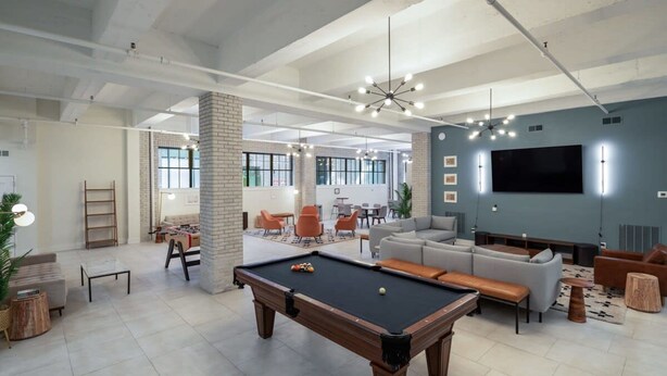 A modern living room with a pool table, sofas, and a large TV. - Sosuite 2BR Loft w W/d, Gym, Lounge (Philadelphia)