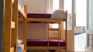 A bunk bed room with wooden frames and purple bedding. - MiBAQ Hostel (Buenos Aires)