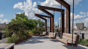 An outdoor seating area with benches and a pergola structure. - Sosuite 2BR Penthouse w Balcony W D Gym (Philadelphia)