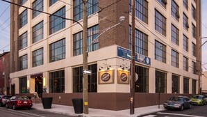 A multi-story building with a brick facade and large windows. - Sosuite 2BR Apt w Balcony, W/d, Gym, On-site Bar (Philadelphia)