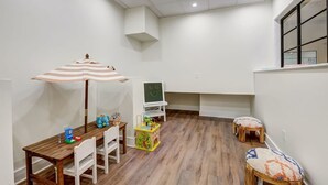 A child-friendly room with a wooden table, chairs, a play area with toys, and a small window. - Sosuite 3BR Apt w Park View, W/d, Gym, Lounge (Philadelphia)
