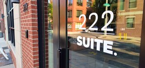 A hotel entrance with the number 222 and the word "SUITE" visible on the glass door. - Sosuite 1BR Apt w W/d, Shared Roofdeck (Philadelphia)