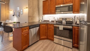 Een moderne keuken met houten kastjes, roestvrijstalen apparatuur en een centraal eiland.