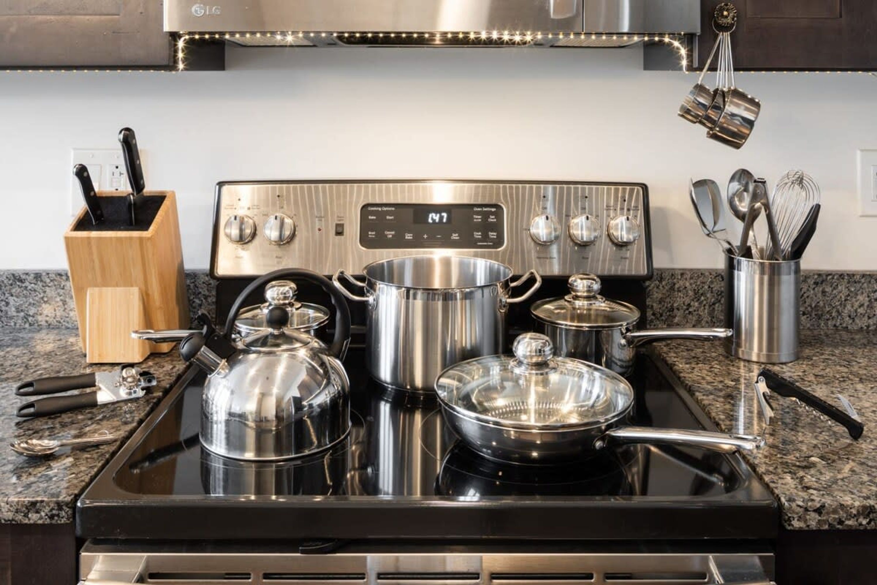 Une cuisine équipée d’une cuisinière en acier inoxydable, de casseroles et d’ustensiles de cuisine.