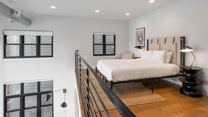 Een slaapkamer met een bed, nachtkastje en raam.