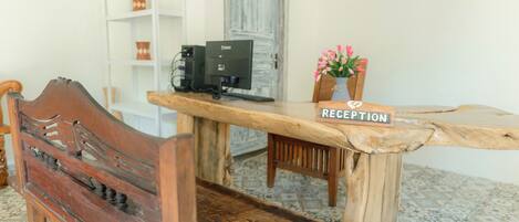 A reception desk with a wooden top and a sign that reads "RECEPTION".
