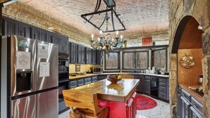 Una cocina moderna con electrodomésticos de acero inoxidable, una isla de madera y una pared de acento roja.
