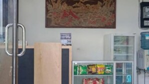 Una habitación con separador de madera, un refrigerador con refrigerios y un dispensador de agua.