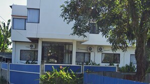 Un edificio moderno con techo plano, ventanas grandes y unidades de aire acondicionado.