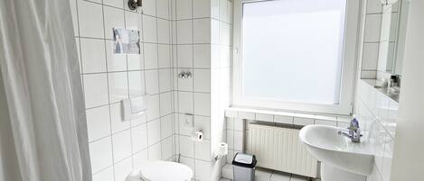 Un baño moderno con inodoro, lavabo y bañera.