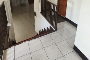 A staircase with a metal railing and a red trim.