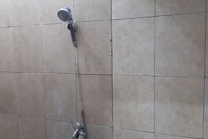 A showerhead mounted on a tiled wall.