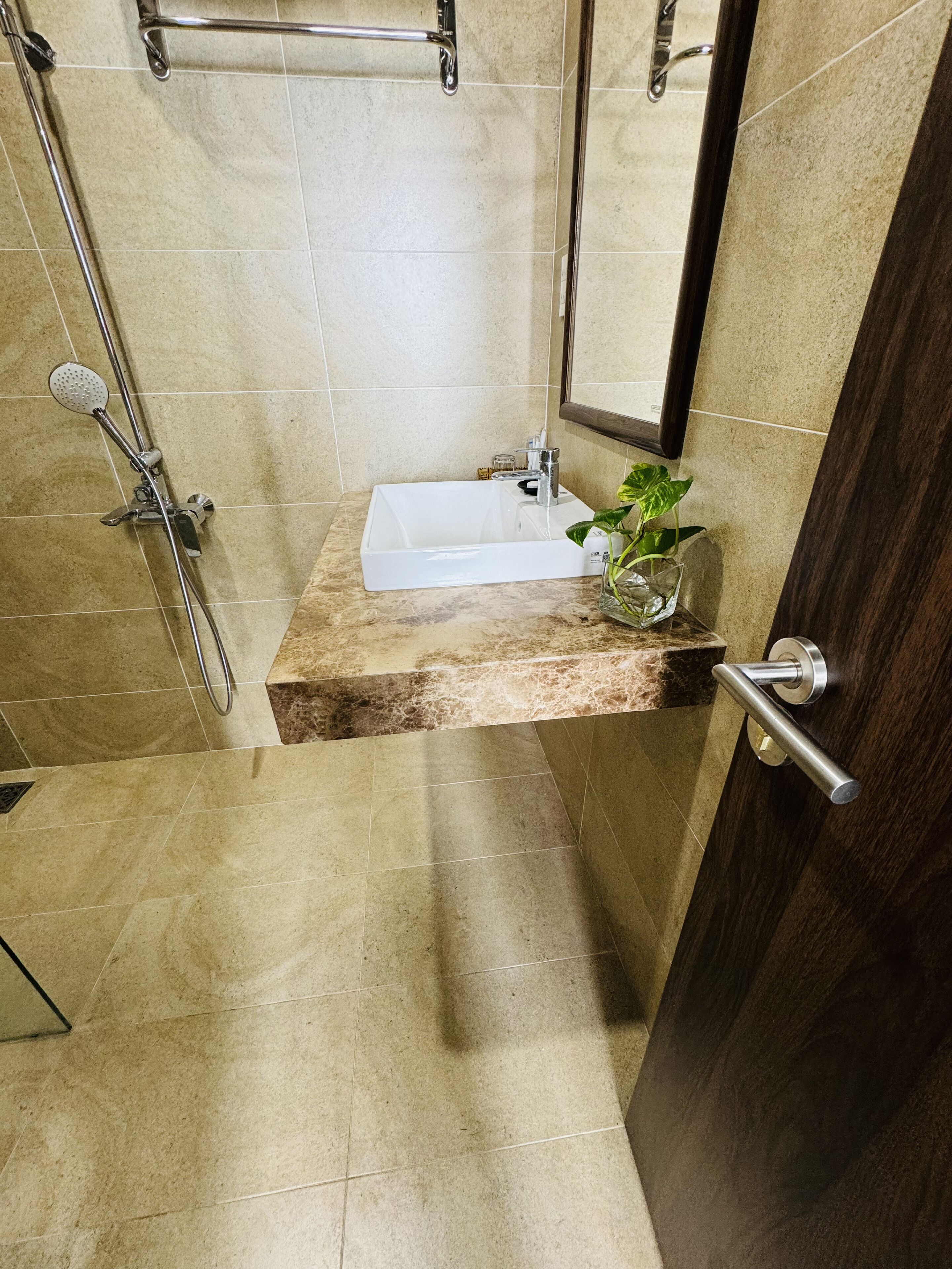 A bathroom with a shower, a sink, and a mirror.