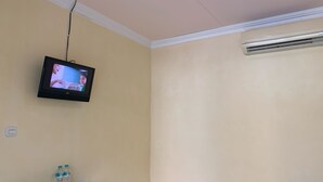 A television mounted on a wall, a water dispenser, and an air conditioning unit.