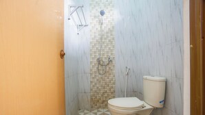 A bathroom with a toilet, a shower, and a tiled floor. - Hotel O Buduran Homestay Syariah (Sidoarjo)