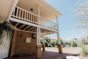 A two-story building with a balcony, brick walls, and a clear sky. - Seascape - Where Coastal Fun and Adventure Meet (Eagle Bay)