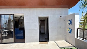 A modern building with a glass entrance, a door labeled 'TOILETTE', and a tiled wall with fish decorations. - Porto Atlantis (Ipojuca)