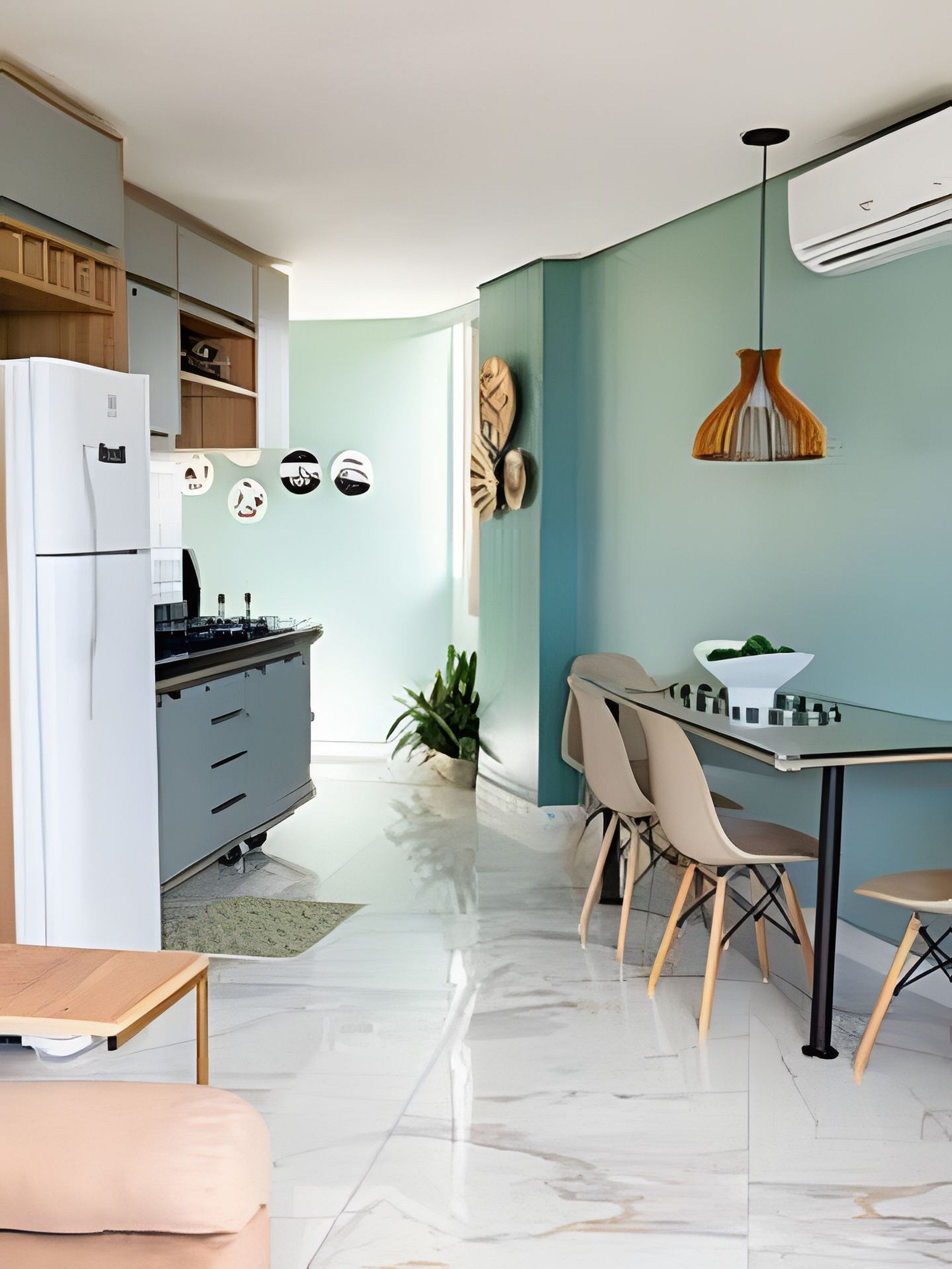 A modern kitchen with a refrigerator, cabinets, and a dining area with a table and chairs.
