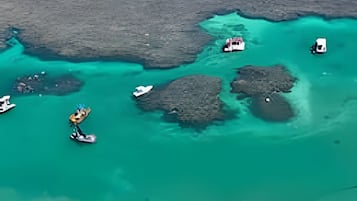 Na praia, areia branca, barracas de praia de cortesia, espreguiçadeiras
