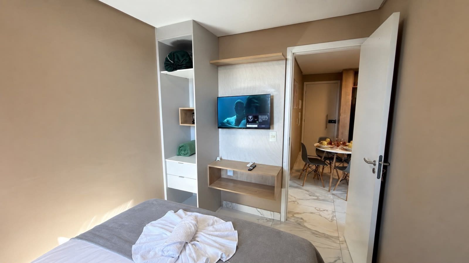 Ein Hotelzimmer mit Bett, Fernseher, Schreibtisch und Essecke.