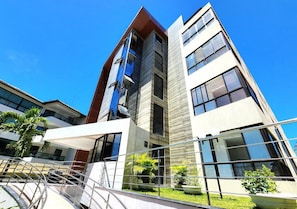 A modern multi-story building with large windows and a glass facade. - Porto Atlantis (Ipojuca)