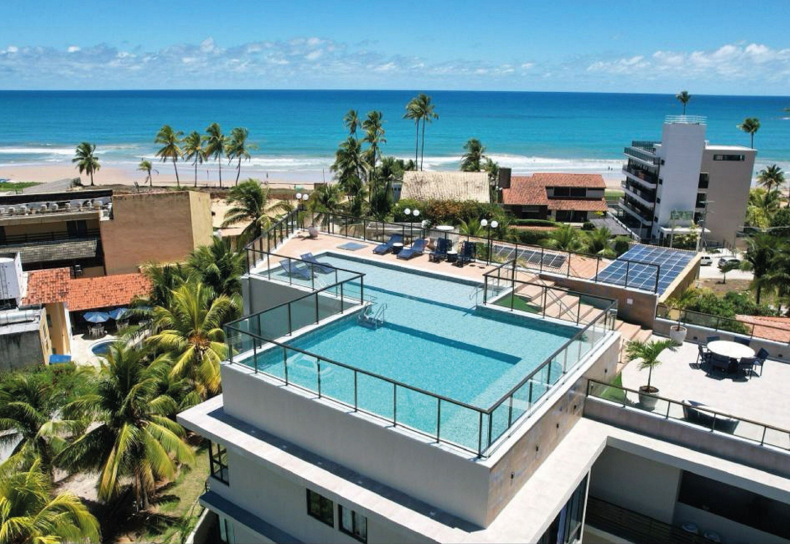 Una piscina al aire libre, sombrillas, sillones reclinables de piscina