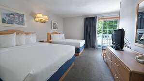 Habitación de hotel con dos camas, televisión, cómoda y ventana con cortinas.