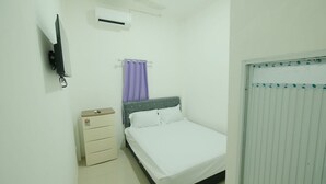 Une chambre à coucher comprenant un lit, une table de chevet, un téléviseur et un appareil de climatisation.