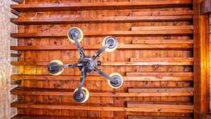 Un plafond avec un ventilateur de plafond à quatre pales dans une pièce en bois.