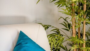 Un canapé en cuir blanc avec un coussin de couleur turquoise.