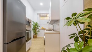 Une cuisine moderne dotée d’appareils électroménagers en acier inoxydable, d’un îlot central et d’une plante en pot.